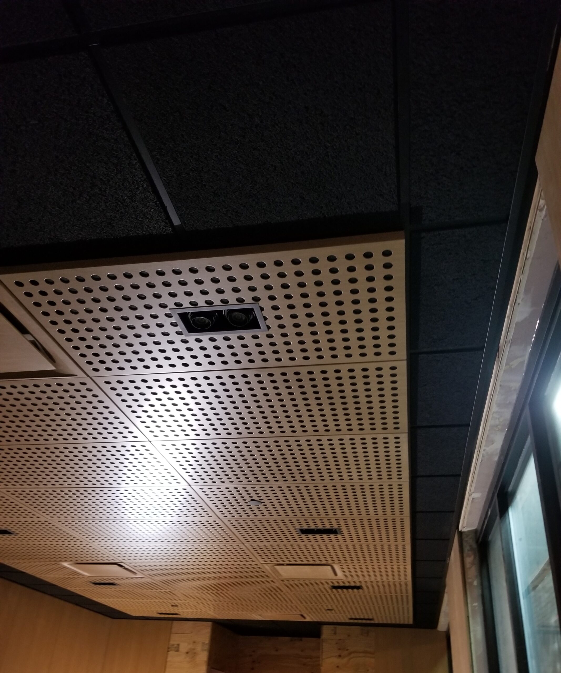 A ceiling with holes in it and a window