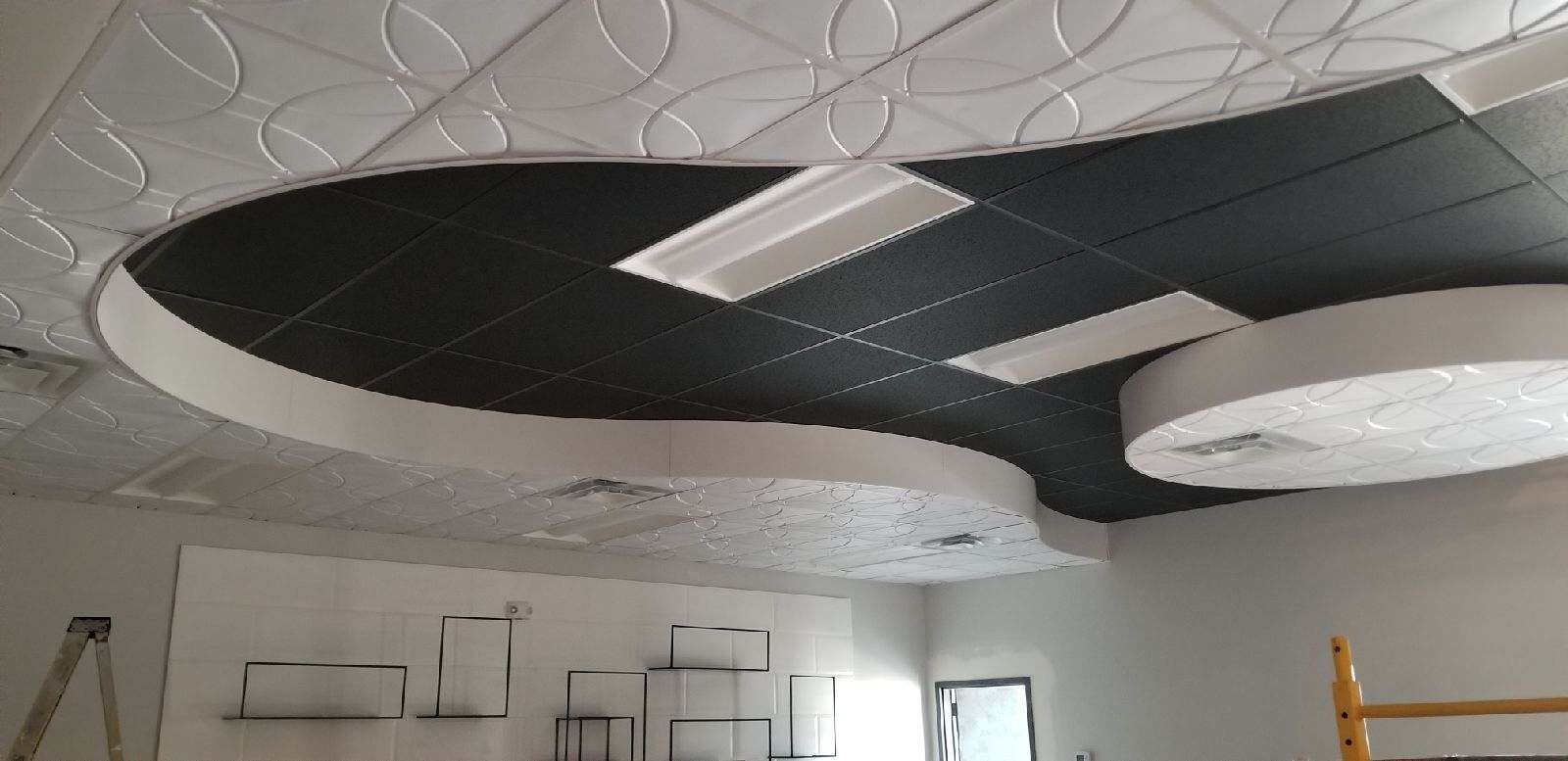A room with many white and black ceiling tiles.